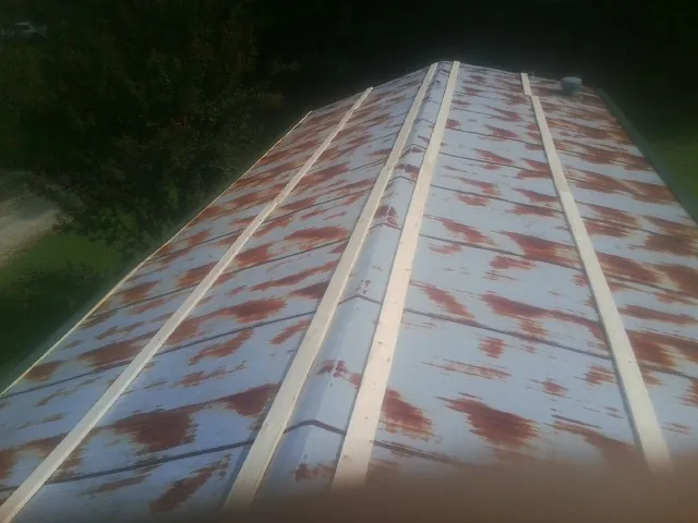 Rusted metal roof panels with new wood purlins before replacement — Storm Damage Roof Repair in Blue Island by Roofing Brothers