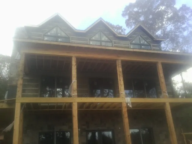 Dormers and porch framing on a large log home under construction — Roof Coating work by our crew in Blue Island