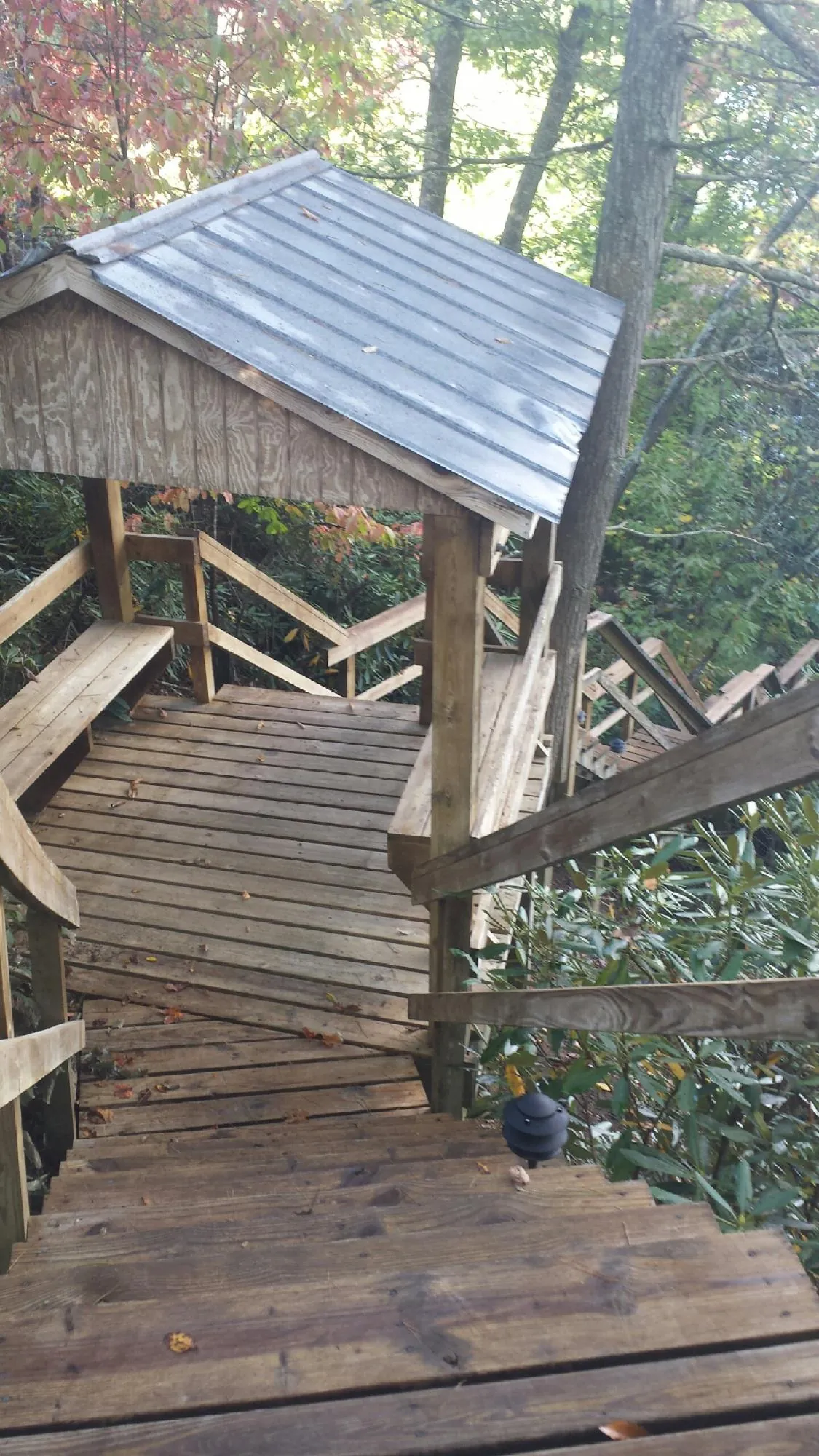 Metal roofed shelter over wooden steps on a wooded walkway — Skylight Repair & Installation work by our crew in Blue Island